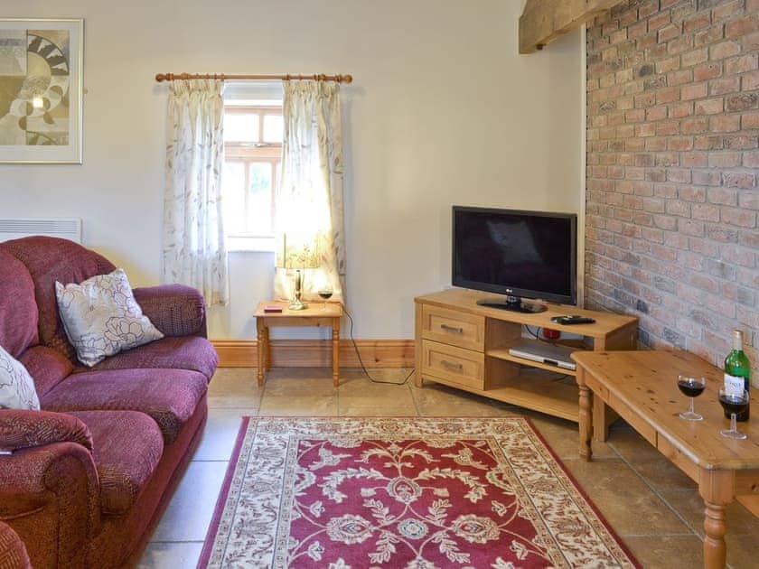 Attractive lounge area with exposed brick feature wall | Ilingworth Cottage - Filey Holiday Cottages, Filey