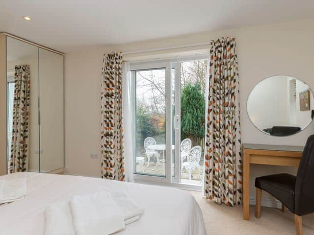 Dressing area of double bedroom with door to patio area | Little Woodlands, Alnmouth, near Alnwick