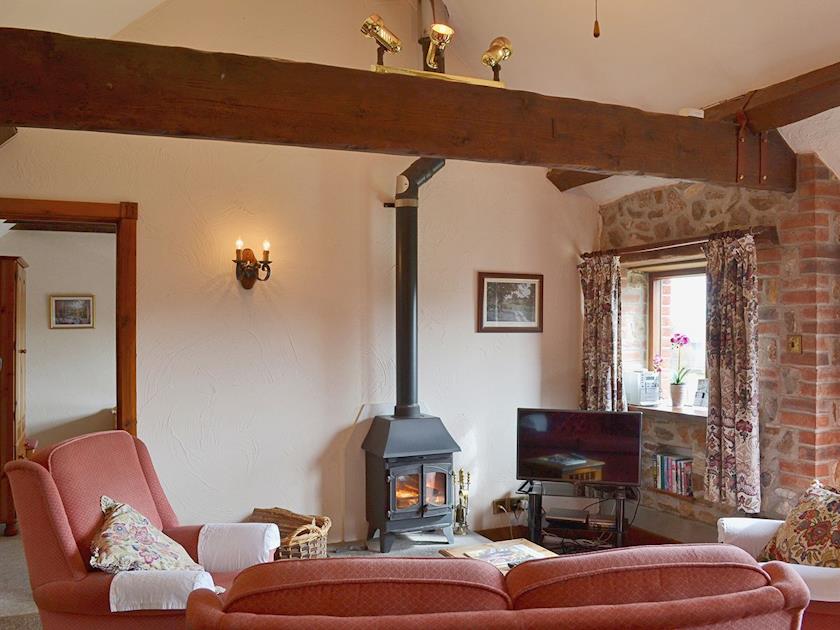The open plan living area has a woodburning stove and exposed beams | Whitwell Farm CottagesAshley&rsquo;s, Whitwell Farm, Colyford, near Seaton