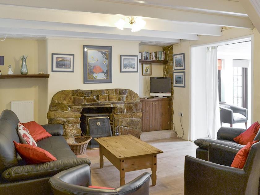 Wooden floors, exposed beams and a feature fireplace make the living room a unique space | Bannsvale Farmhouse - Bannsvale Farm Holiday Cottages, Mount Hawke, near St Agnes