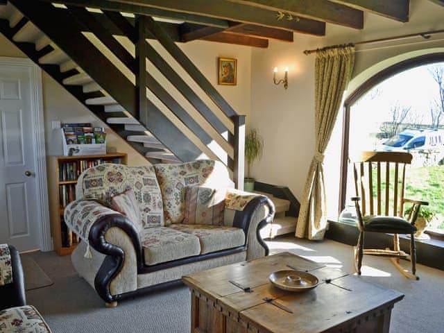 The arched window in the living room maximises its bright and airy ambience | Sandsedge Cottage, Druridge Bay