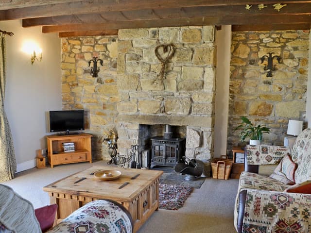 Living room with exposed beams and stone work | Sandsedge Cottage, Druridge Bay