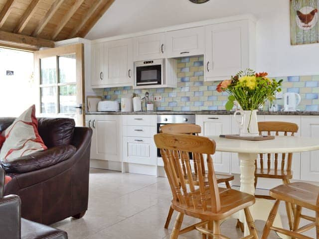 Dining area and well-equipped fitted kitchen | The Parlour - Milton End Farm Barns, Arlingham, near Frampton-on-Severn