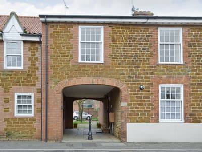 Quirky exterior of property with entrance in archway | Trentham Cottage, Snettisham, near Hunstanton
