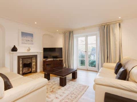 Lovely living room with feature fireplace, wooden floors and satellite television | Elm Grove, Dartmouth
