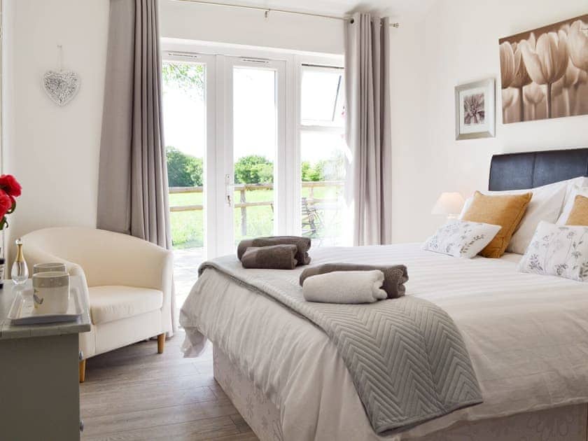 Relaxing en-suite double bedroom with French doors to patio | The Duck House - Dynes Farm, Bilsington, near Ashford