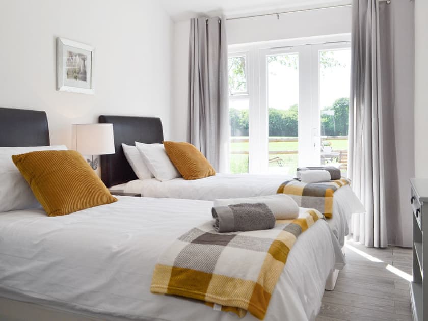 Light and airy twin bedroom with French doors to patio | The Duck House - Dynes Farm, Bilsington, near Ashford