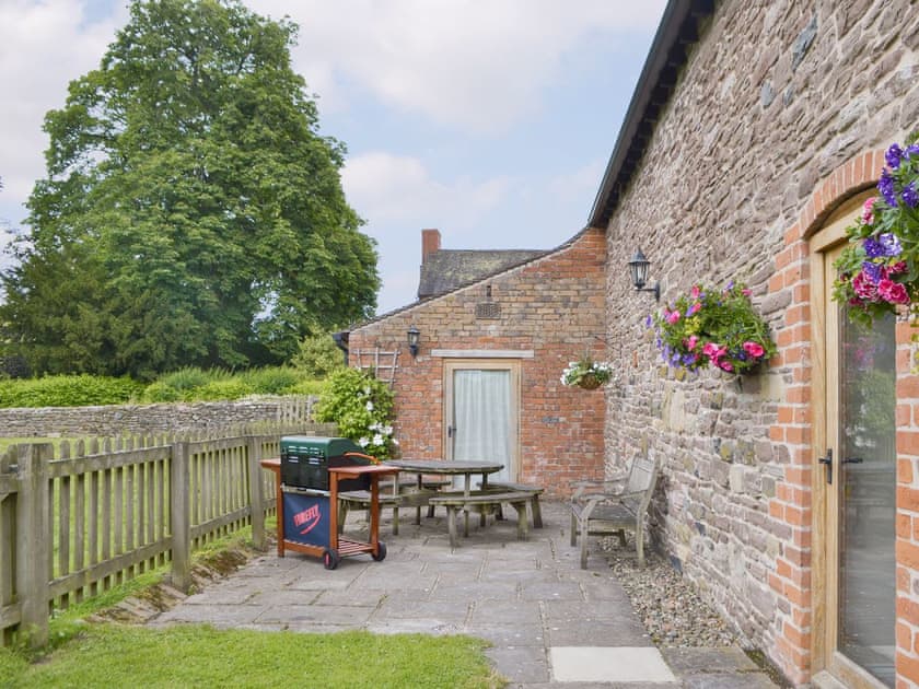 Paved patio area with BBQ to rear of cottage | Stoke Court Farm Barn, Stoke St Milborough, near Ludlow