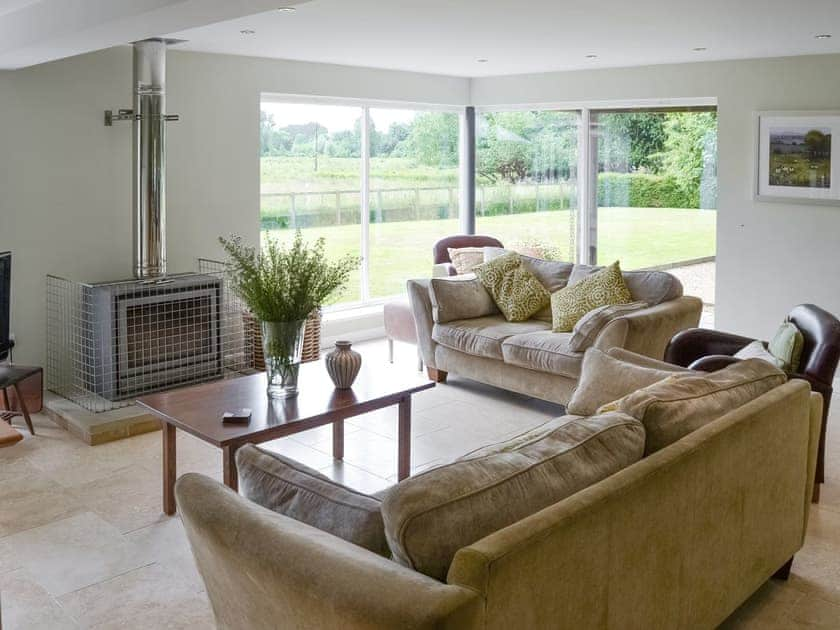 Stylish living area with picture windows overlooking garden | Lock Cottage, Aylsham