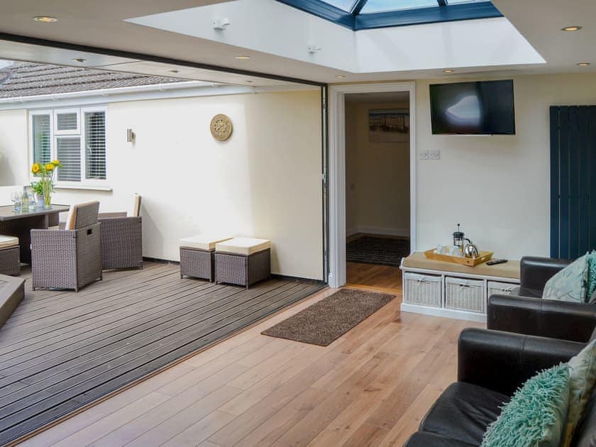 Light and airy sun room with bi-fold doors into the garden | Broadland Hideaway, Martham, near Great Yarmouth