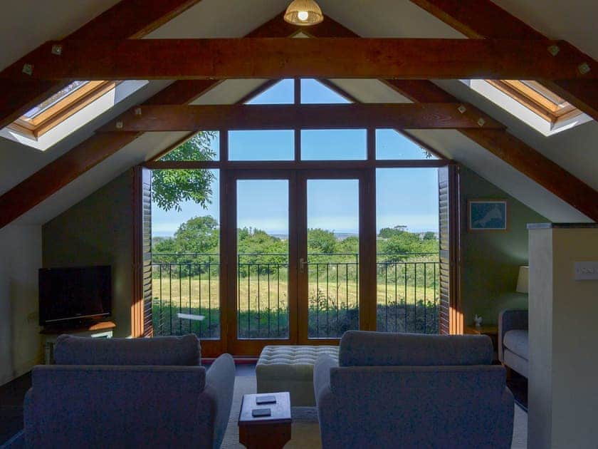 Large windows in the open plan living space offer stunning countryside views | The Roost - Sandy Barn Cottages, St Breward, Bodmin Moor