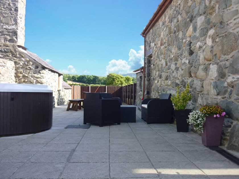 Relax and enjoy a hot tub session on the patio | Bwthyn Meulan, Llandwrog, near Caernarfon