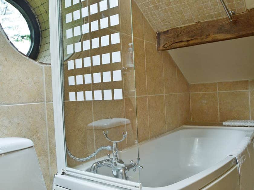 En-suite bathroom with shower over bath | The Pigsty Cottage, Oswestry