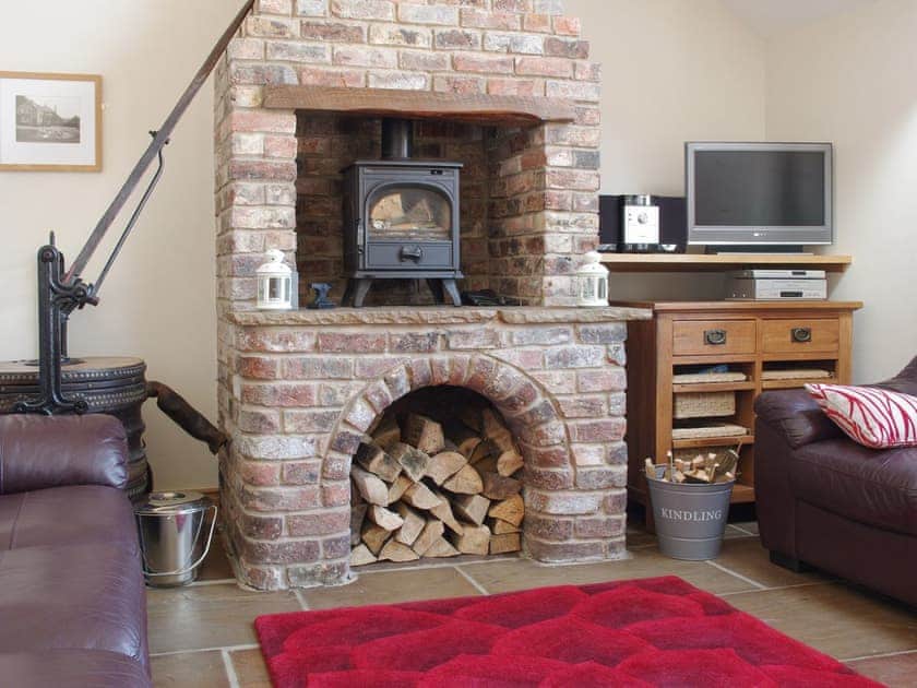 Characterful fireplace with wood burner in living area | The Old Forge, West Lutton near Malton