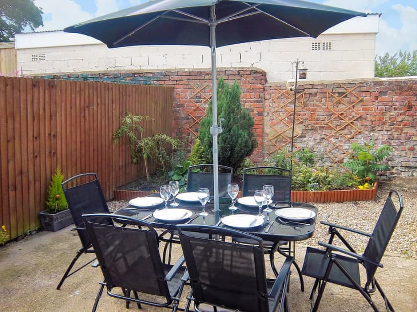 Enclosed courtyard with sitting-out area, garden furniture and barbecue | Church Court Cottage, Beeford, near Hornsea