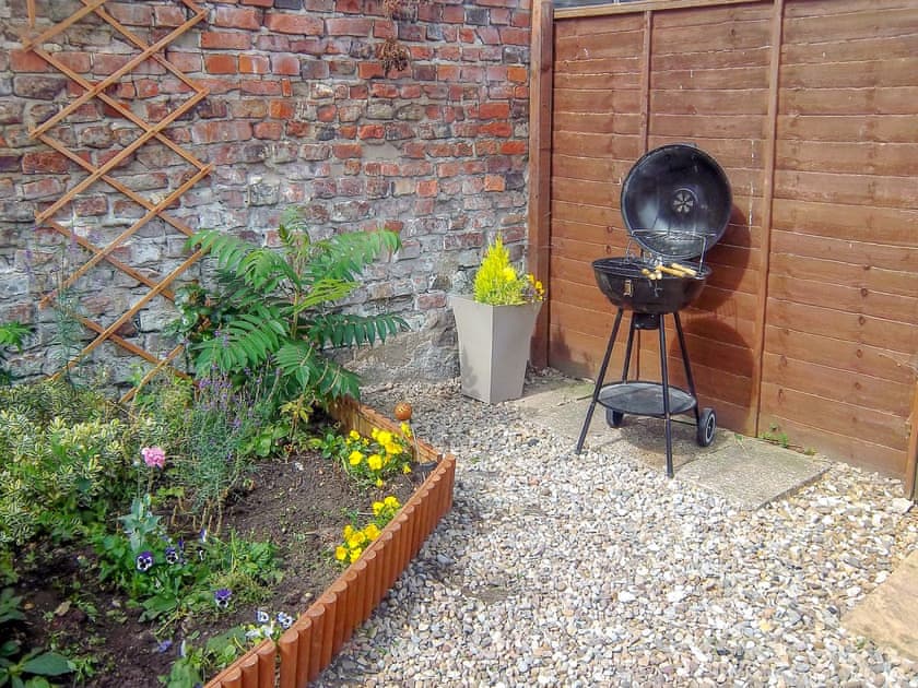 Enclosed courtyard with sitting-out area, garden furniture and barbecue | Church Court Cottage, Beeford, near Hornsea