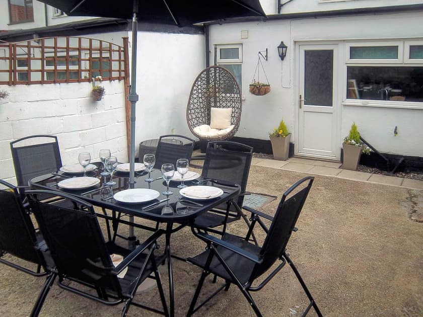 Enclosed courtyard with sitting-out area, garden furniture and barbecue | Church Court Cottage, Beeford, near Hornsea