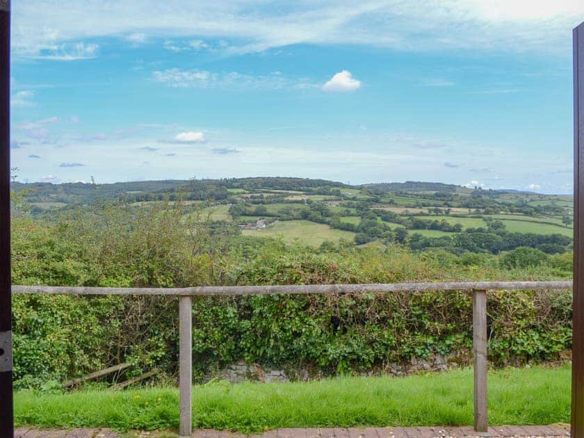 Patio doors open to spectacular, far-reaching panoramic views | The Barn - Smiths Farm Cottages, Charmouth, near Lyme Regis