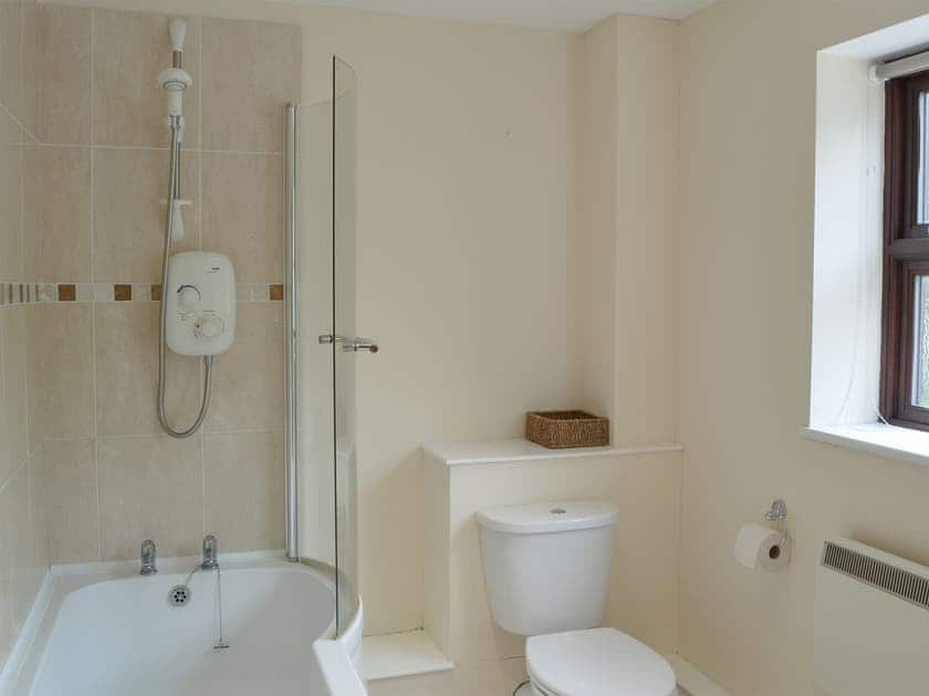 En-suite with shower over bath | The Barn - Smiths Farm Cottages, Charmouth, near Lyme Regis