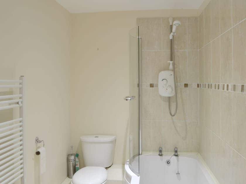 En-suite with shower over bath | The Barn - Smiths Farm Cottages, Charmouth, near Lyme Regis