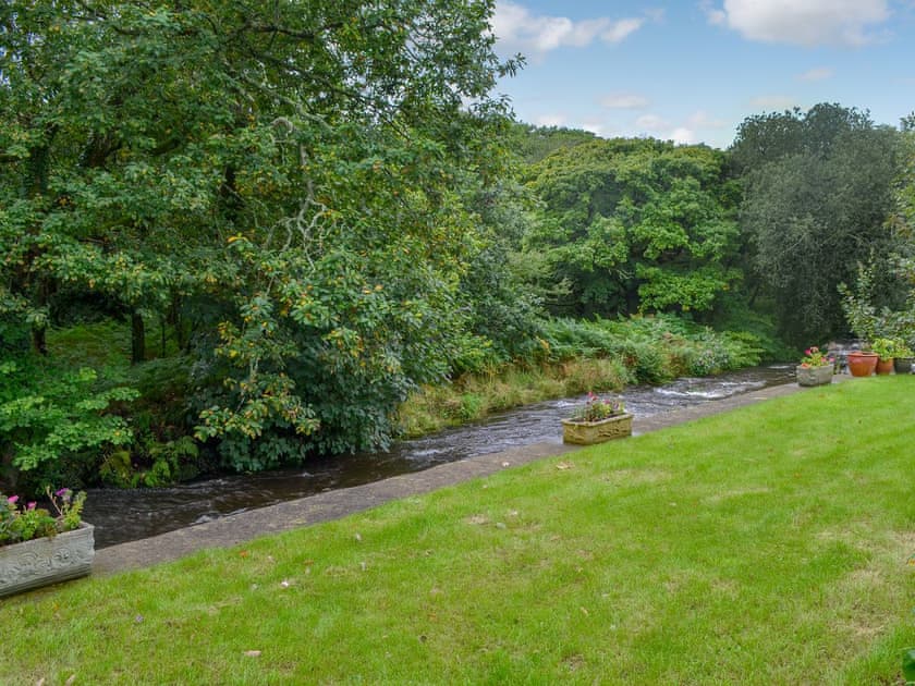 Lawned garden with river running alongside (unfenced)  | Tryfan - The Woollen Mill, Penygroes, near Caernarfon