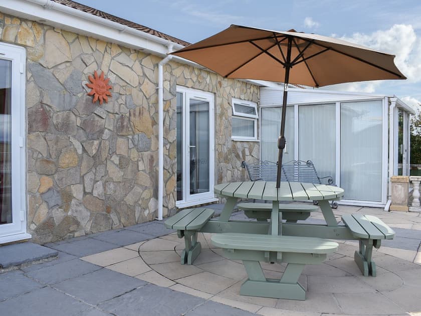 Sheltered spot on the patio for alfresco dining | Sunset Cottage - St Anne’s Cottages, Chickerell, near Weymouth