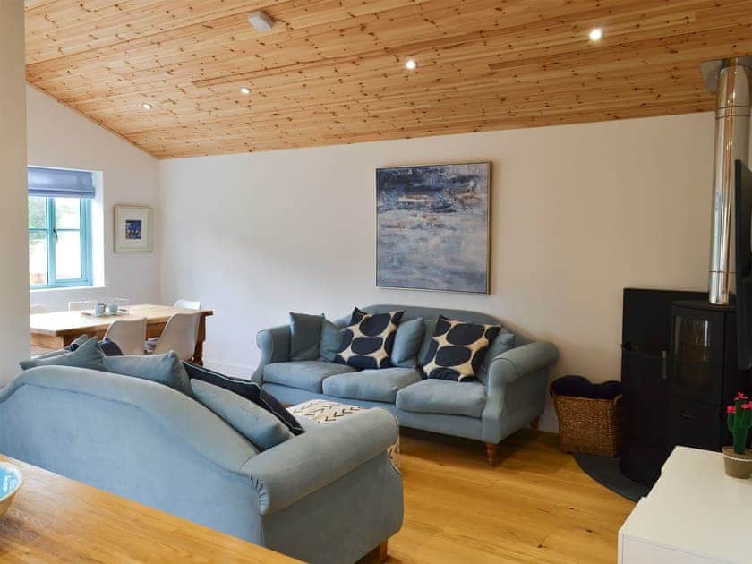 Open plan living space with beams and wooden floor | Eagle Owl Lodge, St Columb Major, near Padstow