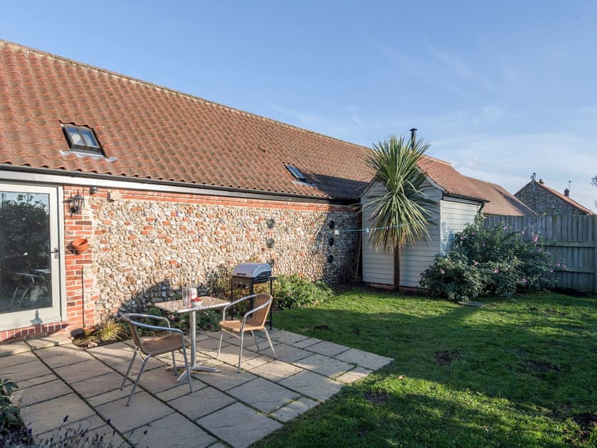 Enclosed lawned courtyard with sitting-out area | The Old Feedhouse - Manor Mews, Tattersett, near Fakenham