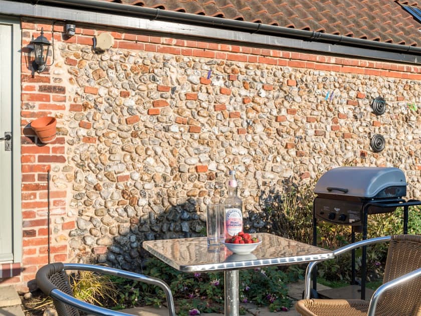 Enclosed lawned courtyard with sitting-out area | The Old Feedhouse - Manor Mews, Tattersett, near Fakenham