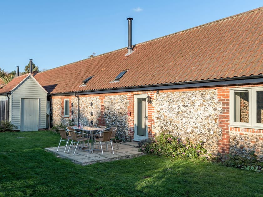 Enclosed lawned courtyard with sitting-out area | The Piggery - Manor Mews, Tattersett, near Fakenham