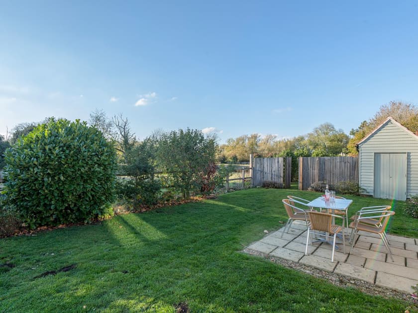 Enclosed lawned courtyard with sitting-out area | The Piggery - Manor Mews, Tattersett, near Fakenham