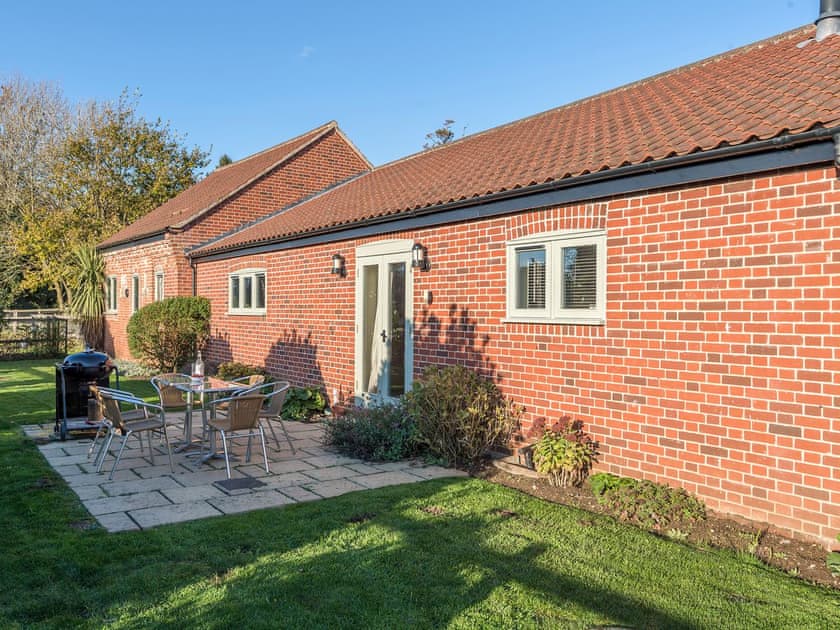 Enclosed lawned courtyard with sitting-out area, garden furniture and BBQ | The Stables - Manor Mews, Tattersett, near Fakenham