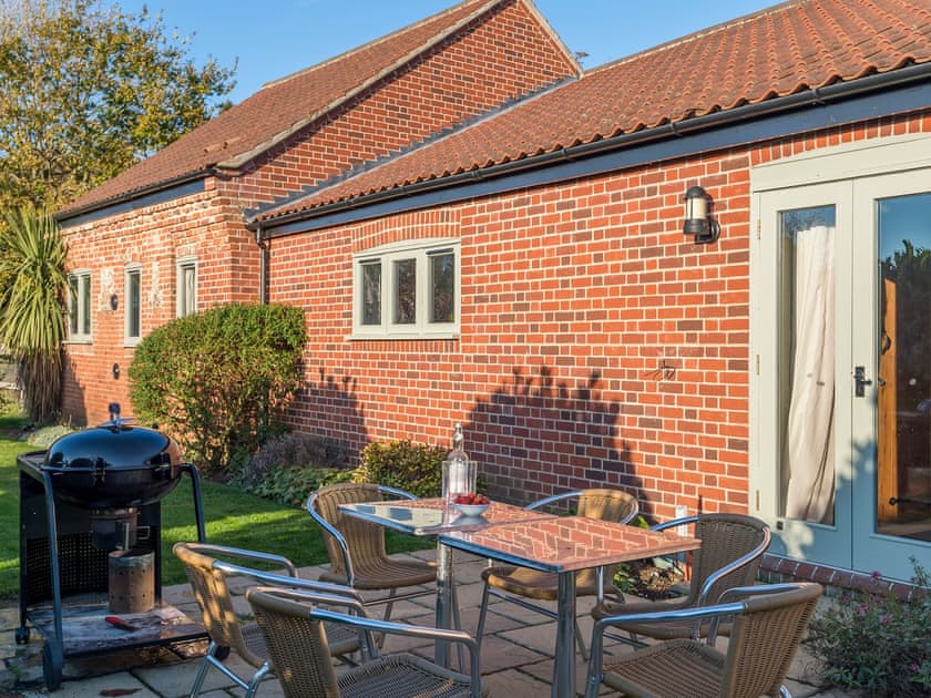 Enclosed lawned courtyard with sitting-out area, garden furniture and BBQ | The Stables - Manor Mews, Tattersett, near Fakenham
