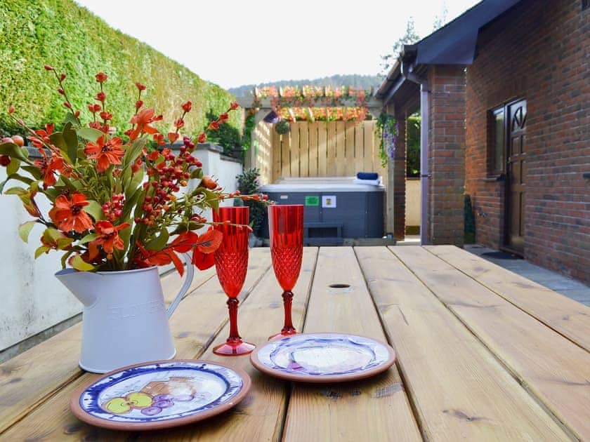 Enclosed courtyard to the rear with sitting-out area, garden furniture and hot tub  | Dyffryn Haidd - Afan Holiday Cottages, llanafan/Aberystwyth