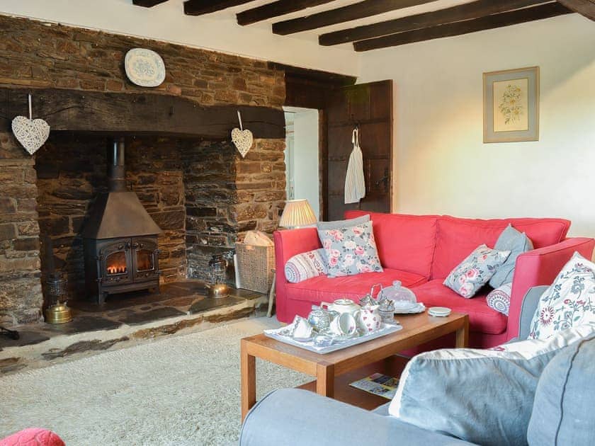 Comfortable living room with feature fireplace home to a wood burning sotve | West Hurscott Cottage, Hurscott, near Barnstaple