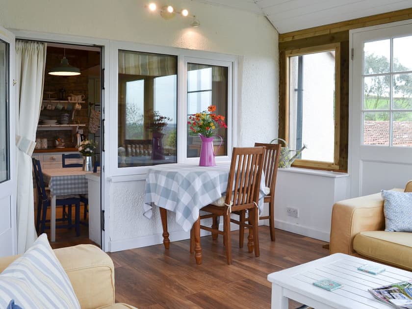 Lovely sun room with modest table and chairs | West Hurscott Cottage, Hurscott, near Barnstaple