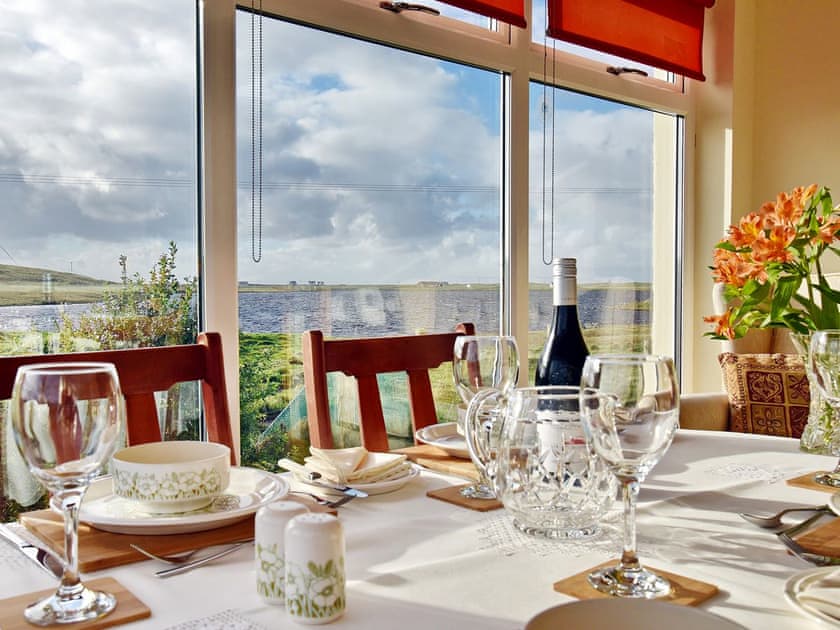 Lovely dining room taking advantage of the stunning views of Loch Roag | Padraig’s Cottage, Howbeg (Tobha Beag), Isle of South Uist