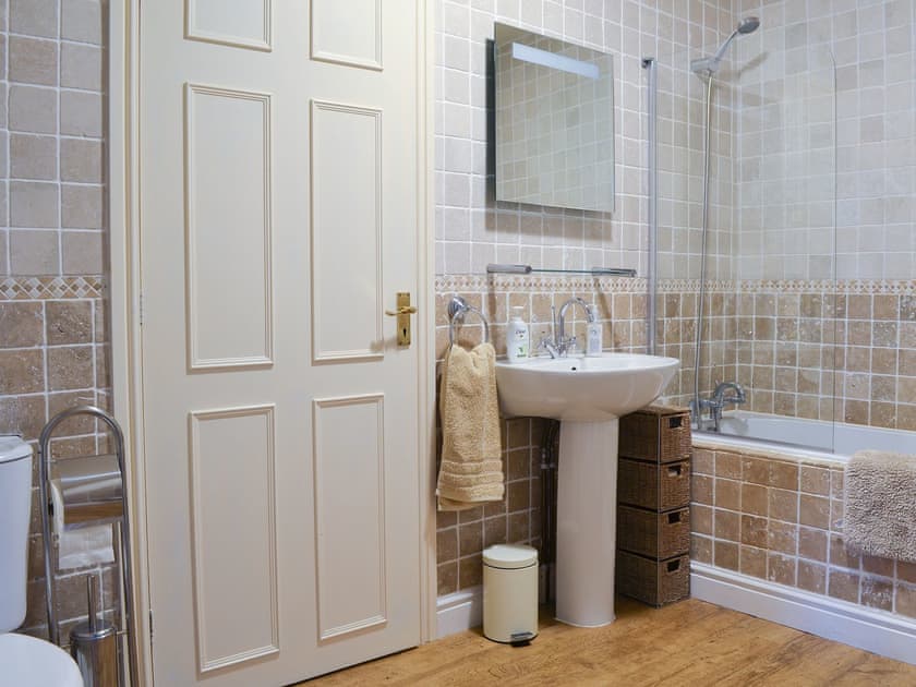 Delightful bathroom with shower over the bath | Ty Canol, Brynteg, Anglesey