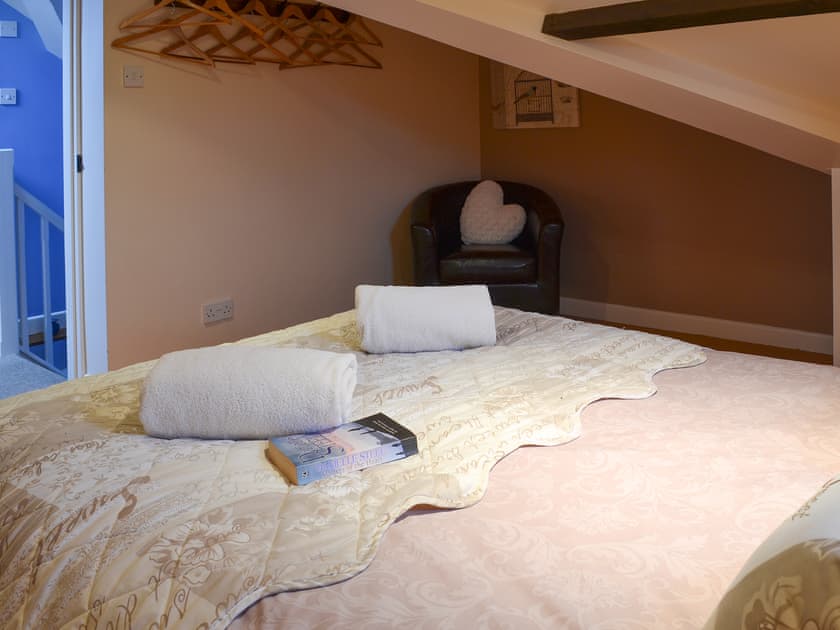 Double bedroom with beams and sloping ceiling | Wheelwright Cottage, Halwill