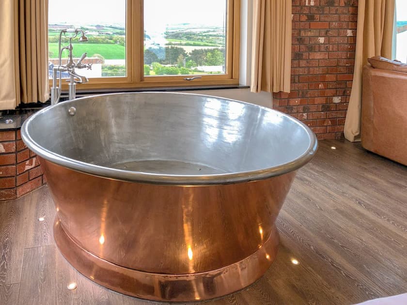 Relaxing copper bath in the bedroom area | Stargazey - Wooldown Holiday Cottages, Marhamchurch, near Bude
