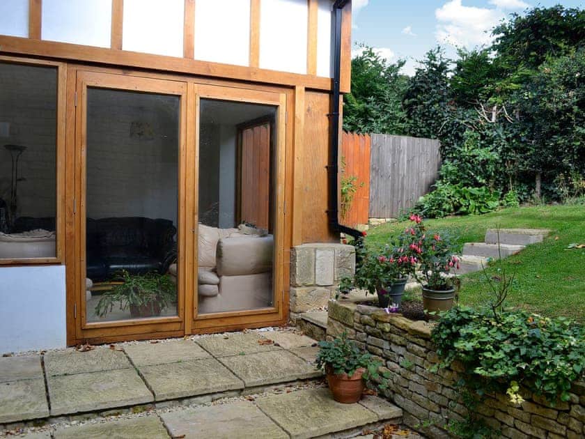 The sun room has French doors which open out to the rear garden | Orchard House, Chipping Campden
