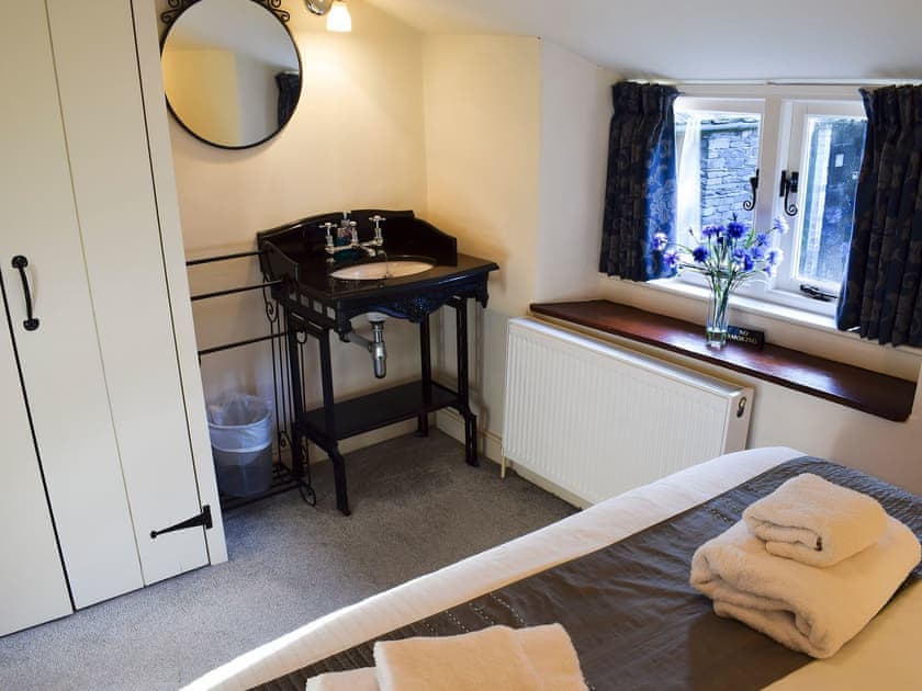 Double cast iron bed and vanity sink unit | A Stone’s Throw Cottage, Ambleside