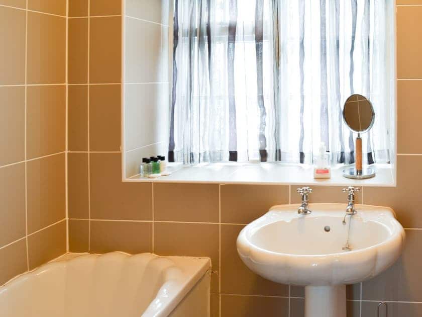 Tiled bathroom with shower over the bath | Brewers Cottage, Cropton, near Pickering