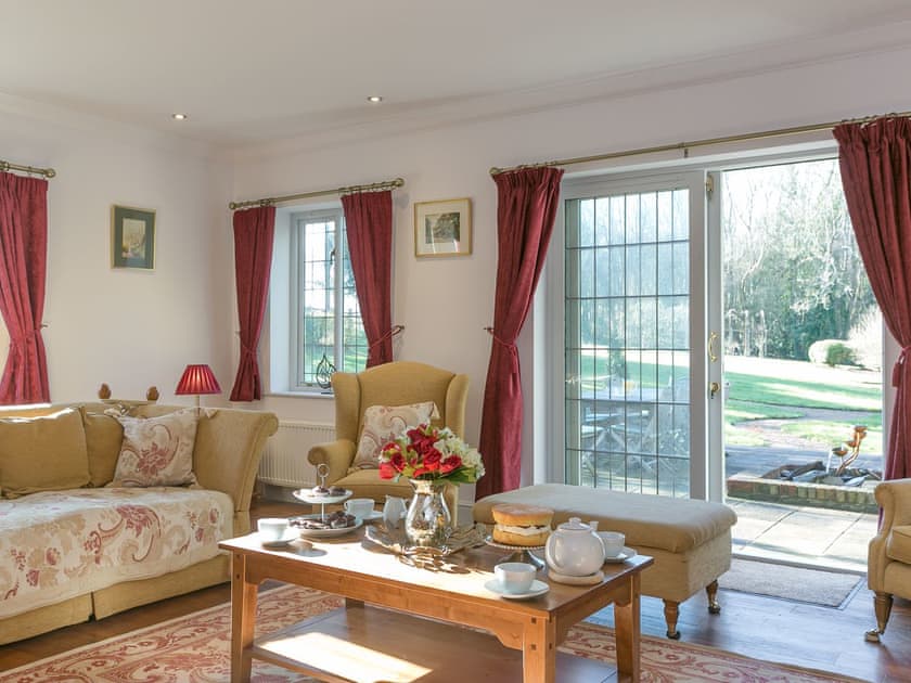 Living room with patio doors leading to garden | Twisly North Lodge, Catsfield, near Battle