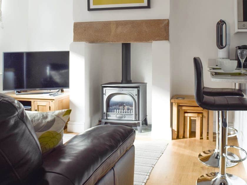 Welcoming living area with wood burner | Ha&rsquo;penny Cottage, Keswick