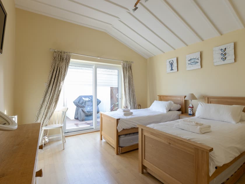 Twin bedroom with stora beds underneath each and sliding patio doors out to teak decked terrace | Lower Marcam, Salcombe
