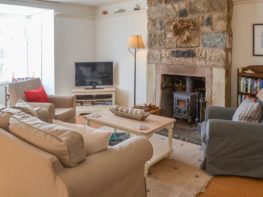 Appealing lounge with stone fireplace and wood-burning stove | Driftwood, Craster
