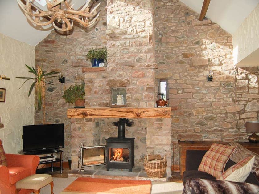 Imposing living room with open fireplace and wood burner | Garden Cottage - Hole House Farm Cottages, Pooley Bridge, Ullswater