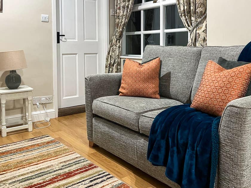 Comfortable living area and adjacent kitchen | The Farriers - The Abbey Coach House, St. Mary’s Park, Windermere