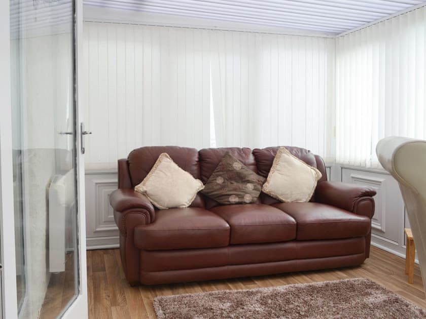Light and airy seating area within conservatory | Pen Parc, Rhosybol, near Amlwch